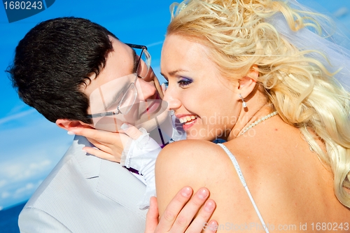 Image of happy groom and bride on a sea coast