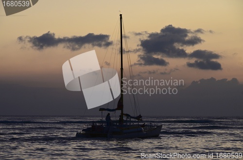 Image of Small pleasure yacht cruising at sunset