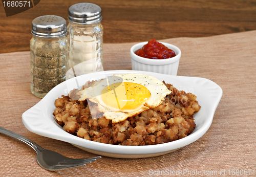 Image of Fried egg on top of roast beef hash.