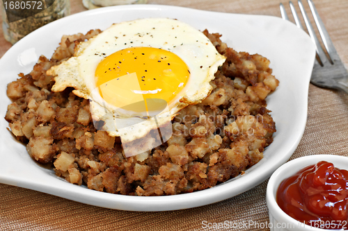 Image of Fried egg on top of roast beef hash.