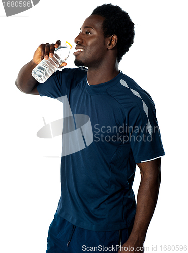 Image of Tired african athlete drinking water