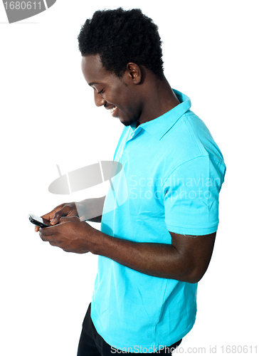 Image of African boy busy messaging