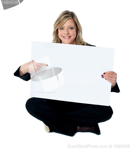 Image of Professional female executive pointing towards billboard