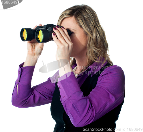 Image of Businesswoman looking through binoculars