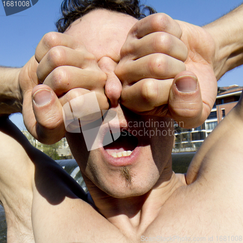 Image of Man's nose between two robust fists.