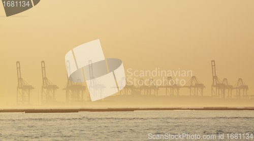 Image of container cranes on a foggy morning