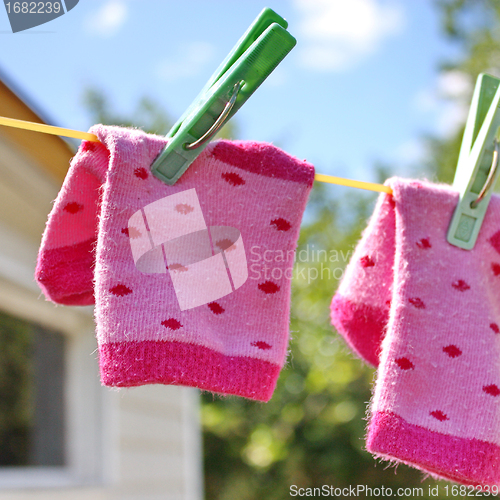 Image of Pink baby sock hanging on the clothesline