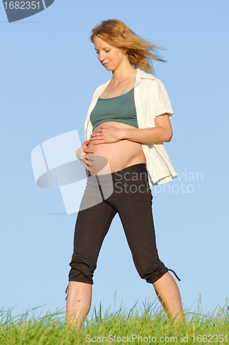 Image of pregnant woman on meadow