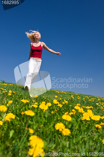 Image of young woman in red outfit having fun on meadow