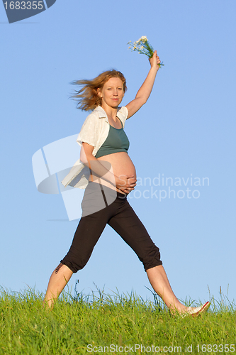 Image of pregnant woman on meadow