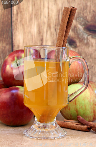 Image of Apple cider with cinnamon sticks and apples.