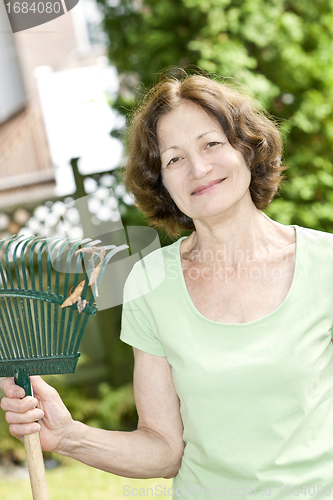 Image of Senior woman holding rake