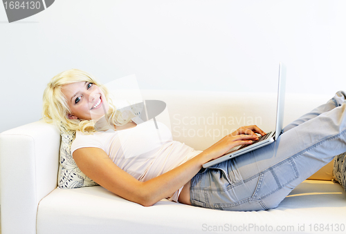 Image of Woman lying on couch with laptop