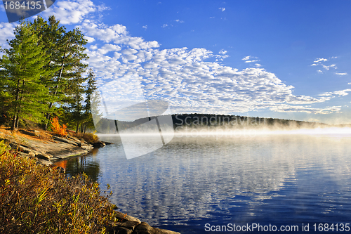 Image of Autumn lake shore with fog