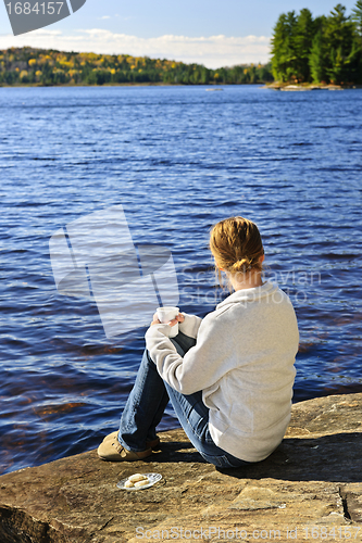 Image of Woman relaxing at beautiful lake