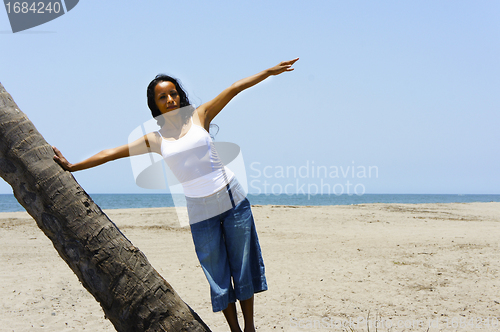 Image of Woman leaning on a palm tree