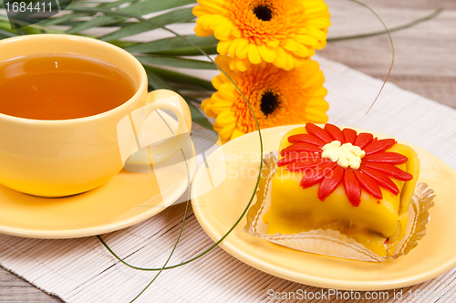 Image of tea with cake and gerberas flowers