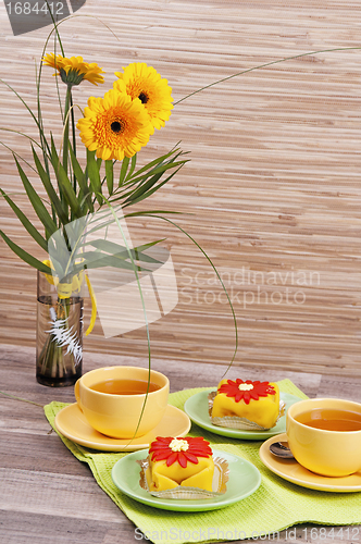 Image of tea with cake and gerberas flowers