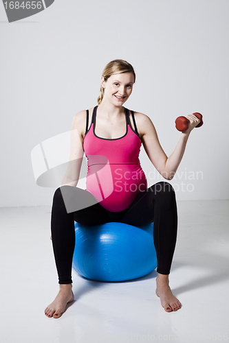 Image of Pregnant woman exercising with dumbbells