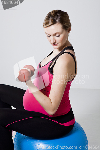 Image of Pregnant woman exercising with dumbbells