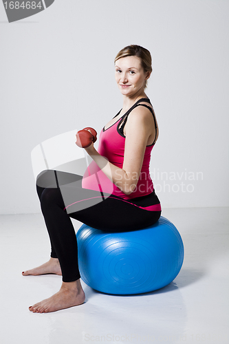 Image of Pregnant woman exercising with dumbbells