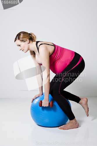 Image of Pregnant woman exercising with dumbbells