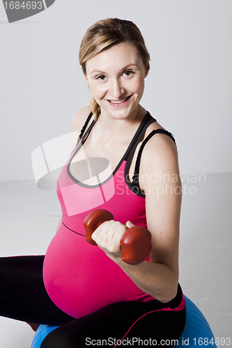 Image of Pregnant woman exercising with dumbbells