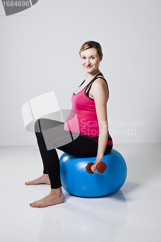 Image of Pregnant woman exercising with dumbbells