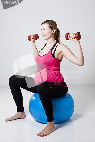 Image of Pregnant woman exercising with dumbbells