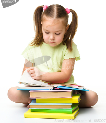 Image of Cute little girl reads a book