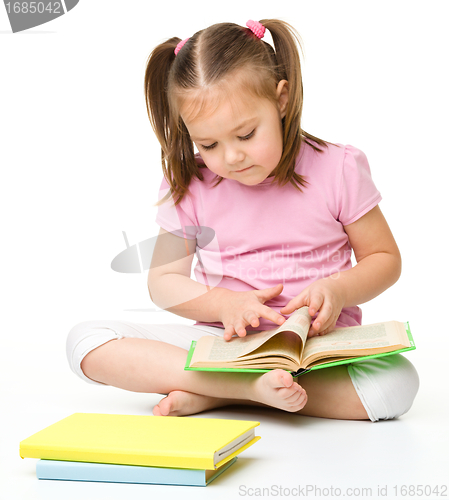 Image of Cute little girl reads a book