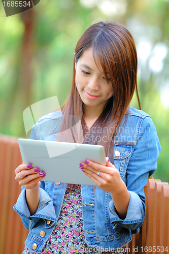 Image of young asian woman with tablet computer outdoor