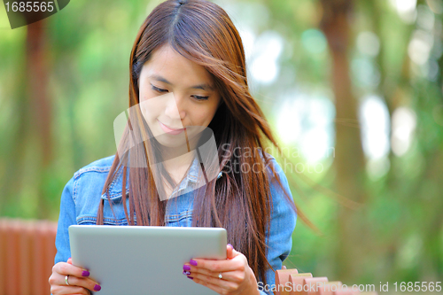 Image of young asian woman with tablet computer outdoor