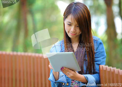 Image of young asian woman with tablet computer