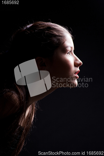 Image of young girl lasting forward to light on black