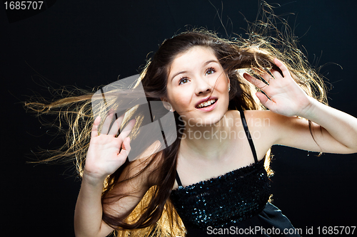 Image of  cute girl  lasting towards to wind and light on black