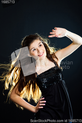 Image of  cute girl  lasting towards to light on black