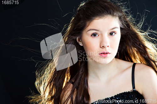 Image of cute teenager girl with  beautiful long dark hair  on black