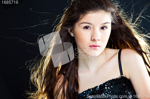 Image of cute teenager girl with  beautiful long dark hair  on black