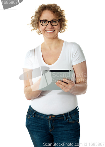 Image of Senior woman holding tablet, smiling