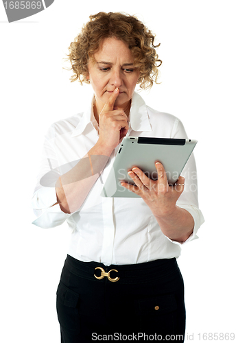 Image of Businesswoman looking at tablet and thinking deep