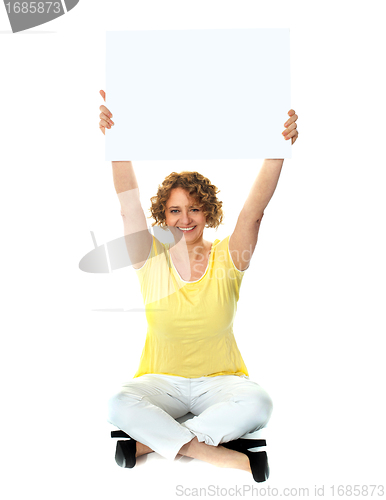 Image of Seated woman holding blank billboard