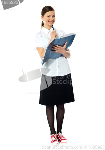 Image of School girl thinking and smiling at camera