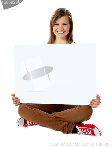 Image of Smiling pretty teenager posing with blank placard