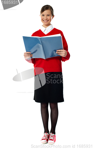Image of Smiling girl standing with exercise book