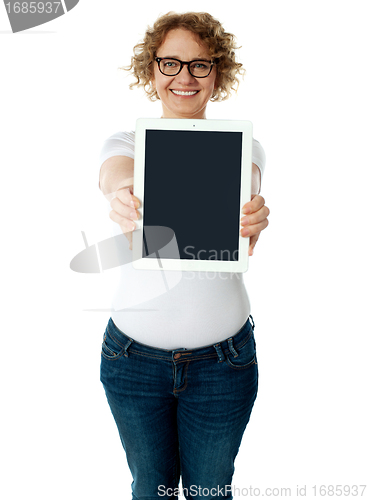 Image of Woman showing tablet screen to camera