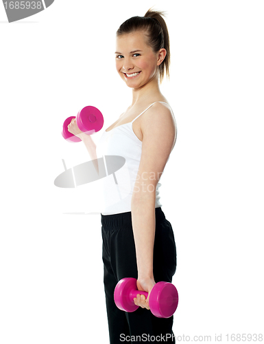 Image of Strong teenager working out with dumbbells