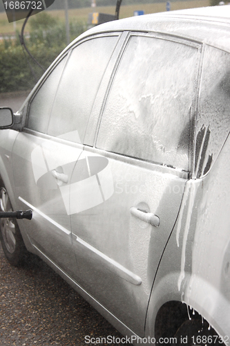 Image of a car wash with a jet of water and shampoo