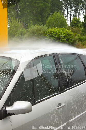 Image of a car wash with a jet of water and shampoo