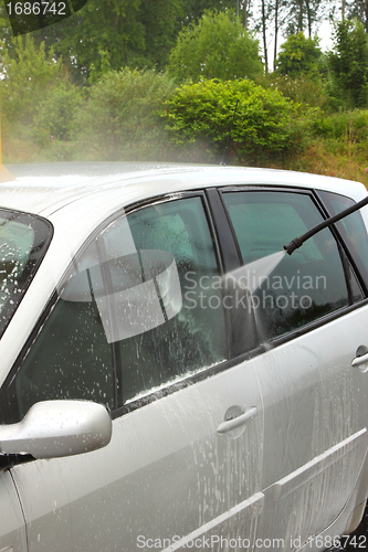 Image of a car wash with a jet of water and shampoo